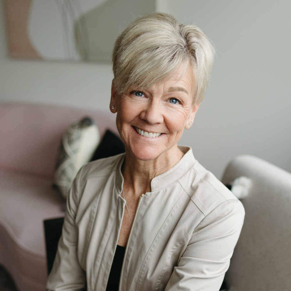 Woman with short blonde hair smiling.