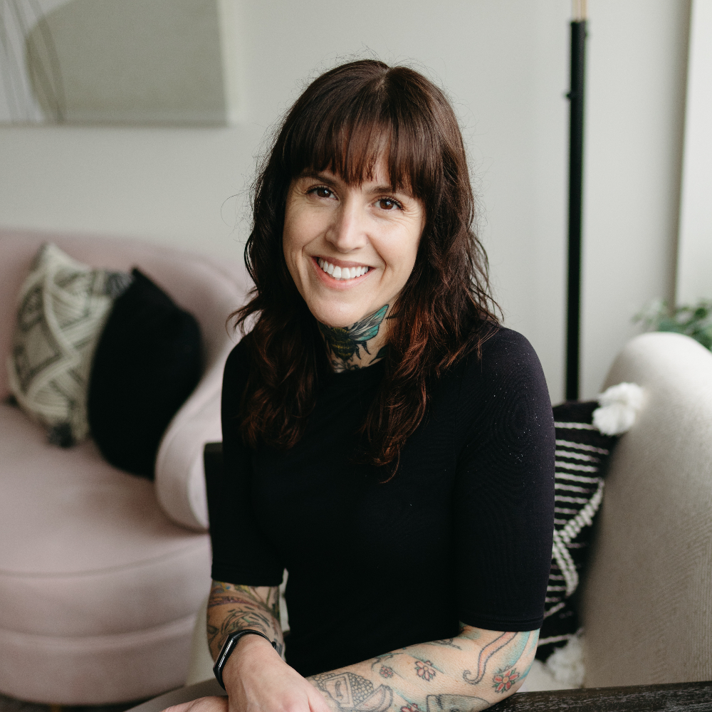 Woman sitting on the floor and smiling at the camera.