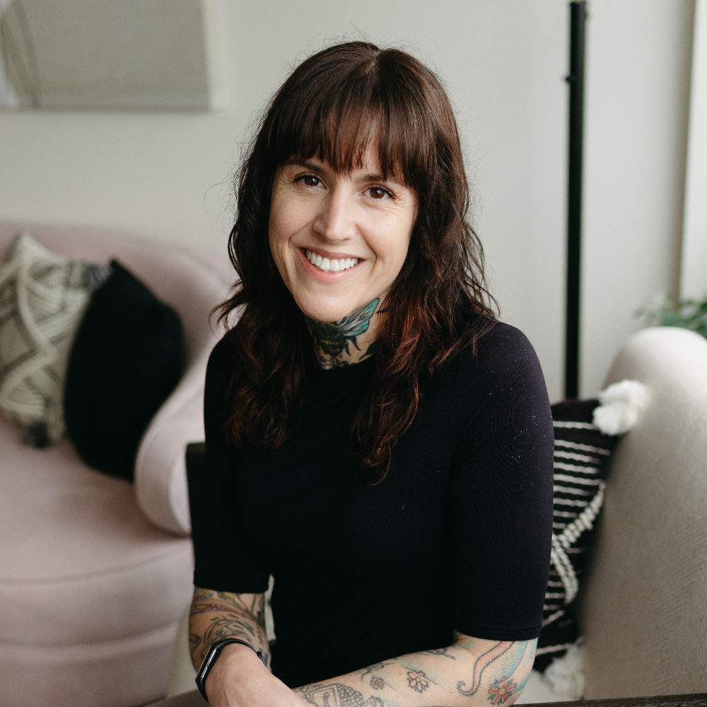 Brunette sitting and smiling at the camera.