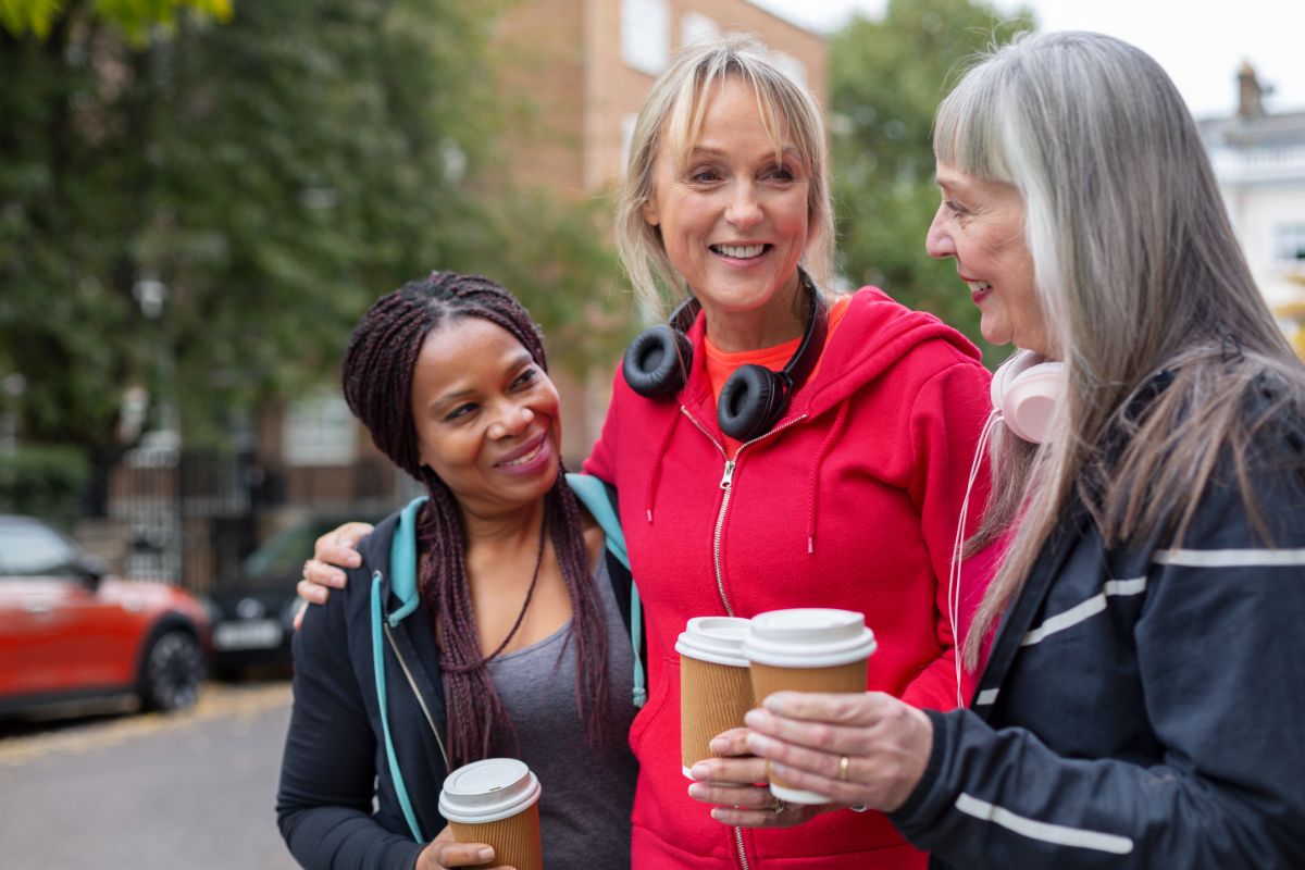 Three women holding coffees.